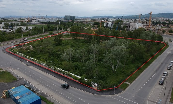 Bauplatz O mit Grundstückslinien umrundet von befahrenen Straßen