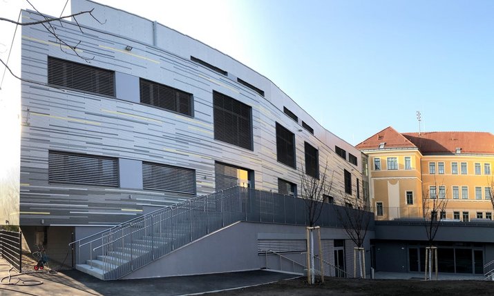 Moderne Schulerweiterung mit sichtbarer durchgehender Verbindung zum alten Schulgebäude