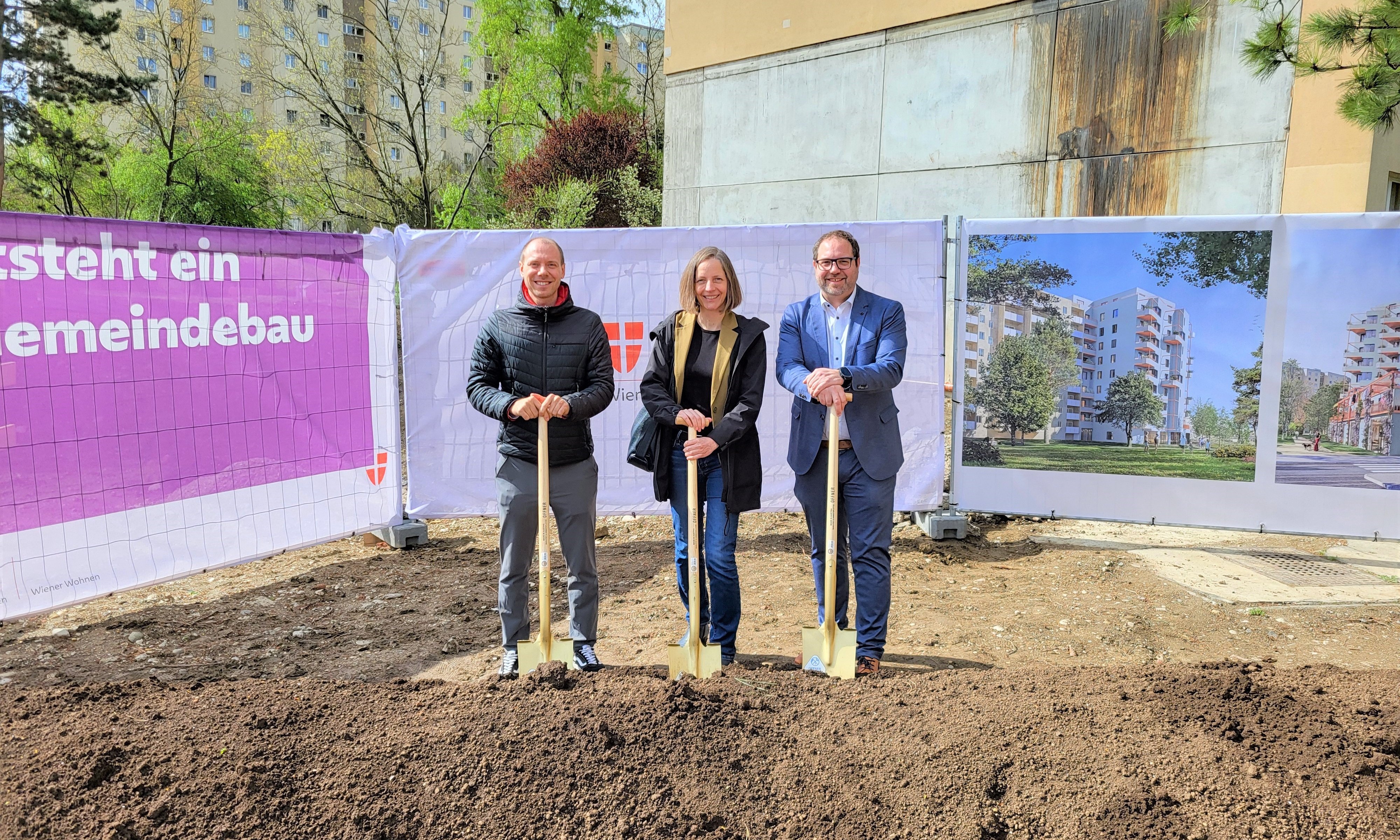 Team von 3 Personen lehnen auf Spaten auf der Baustelle vor Bauzäunen