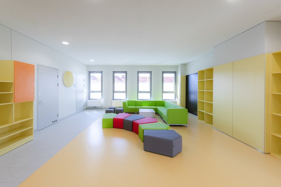 Einladendes helles Klassenzimmer mit großen Fenstern und bunten bequemen Sitzgelegenheiten
