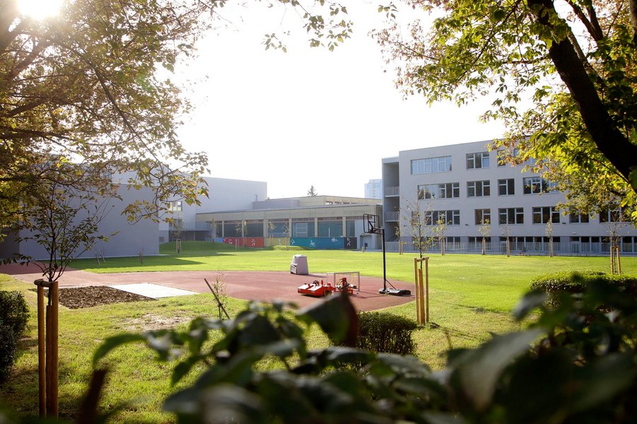 Grüner Hof der Schule mit einem Basketballkorb