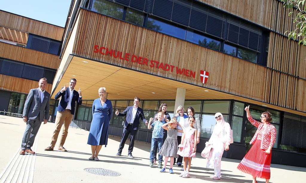 Mehrere Personen stehen vor dem Schuleingang